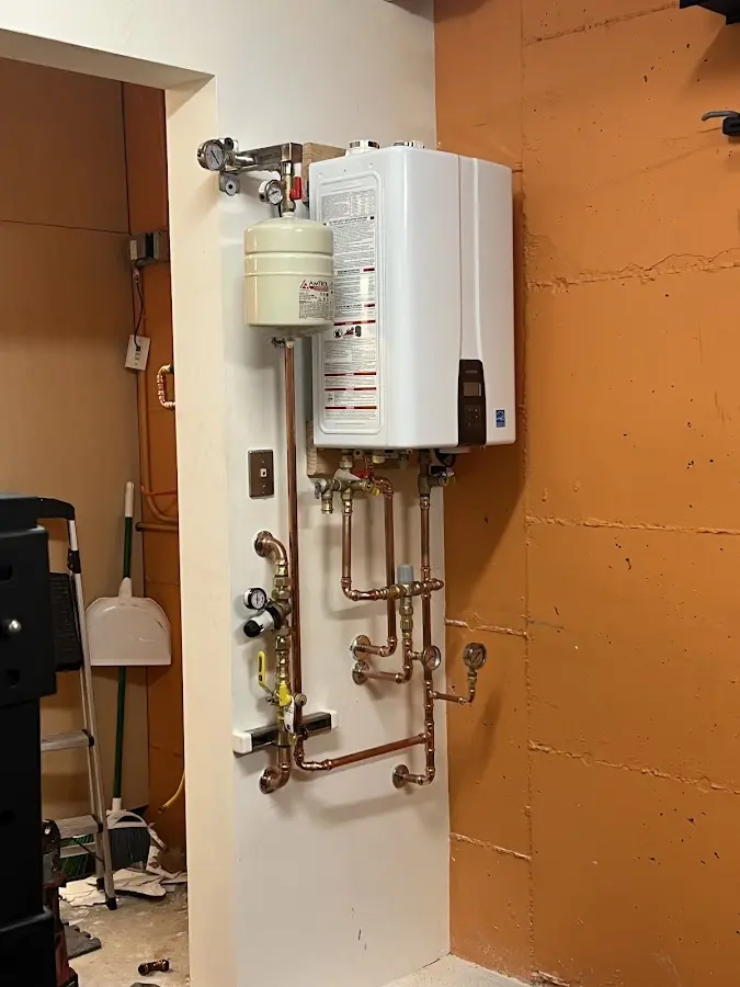 Plumbing technician inspecting water heater connections in Connoquenessing